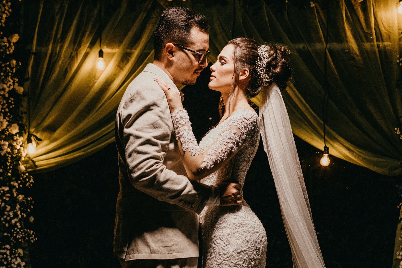 A newly-wed couple dance together at their wedding reception under a spotlight