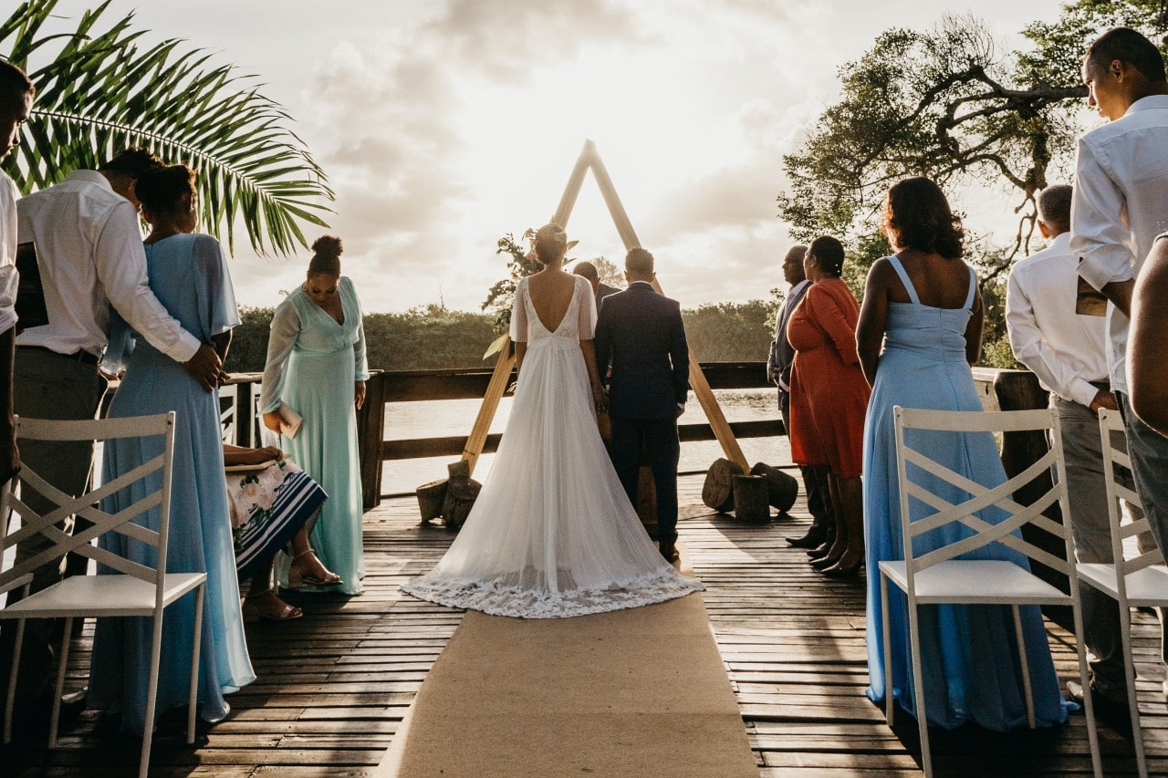 A bride and groom stand at the altar at a tropical outdoor wedding ceremony