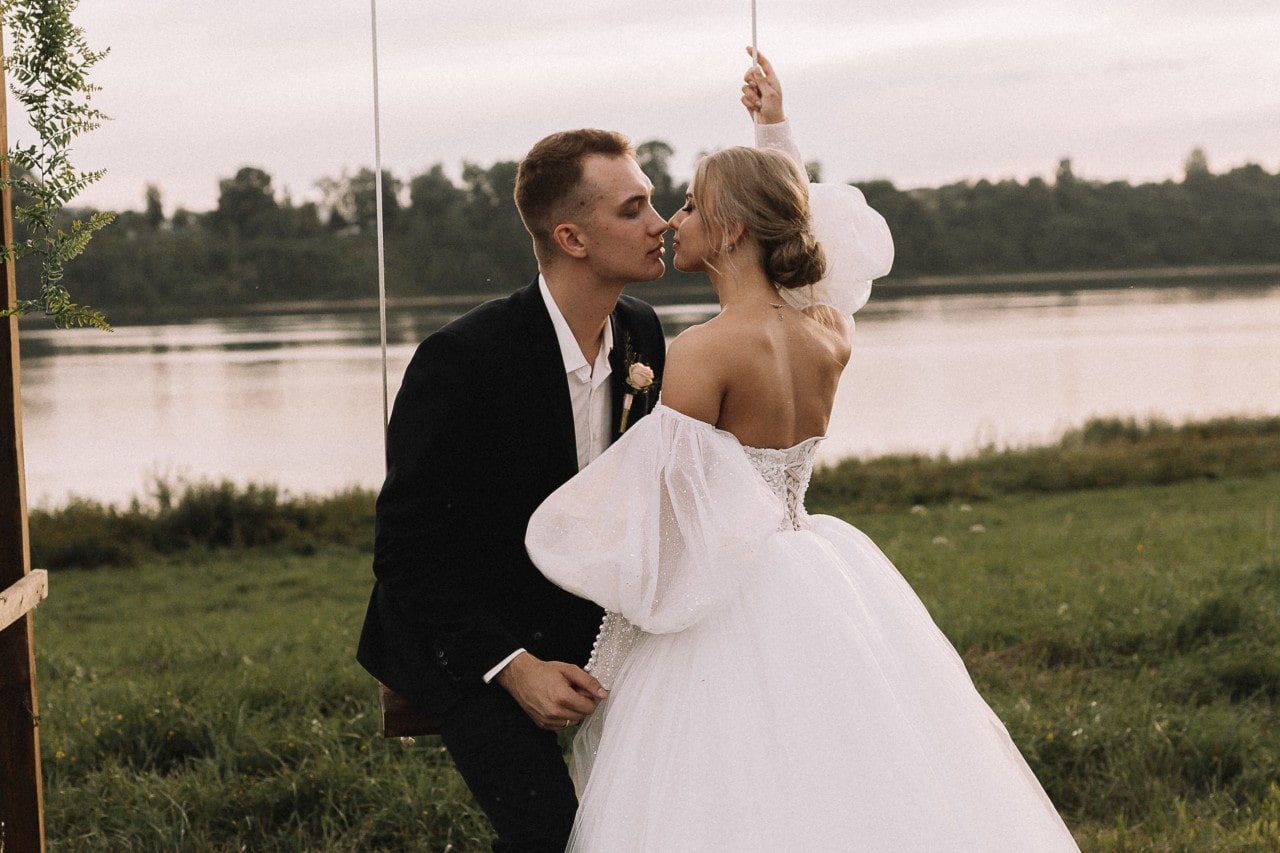 A newly-wed couple share an intimate moment on a swing set