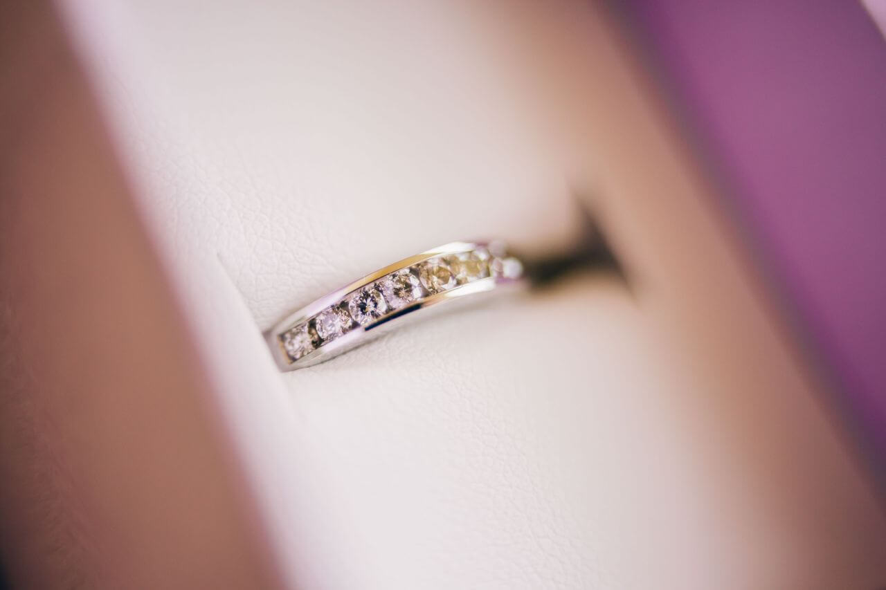 a white gold, channel set diamond wedding band in a ring box