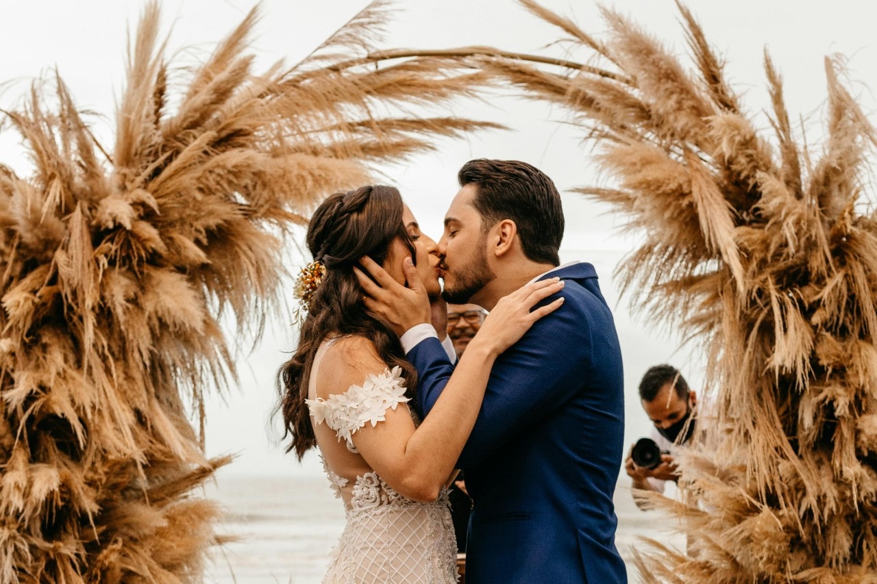 a bride and groom embracing at a fall themed altar on the beach