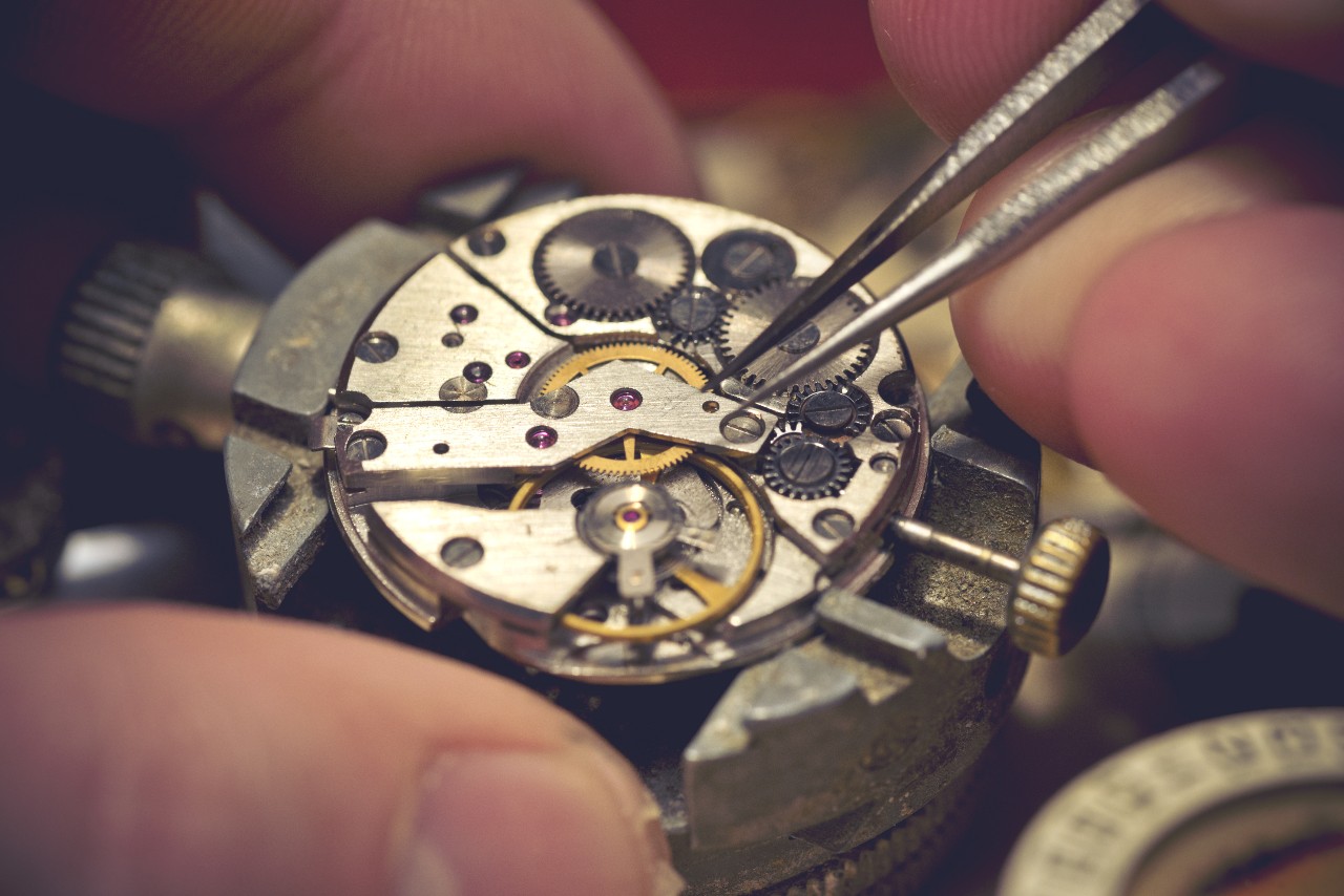 A close-up of an artisan maintaining a luxury watch.