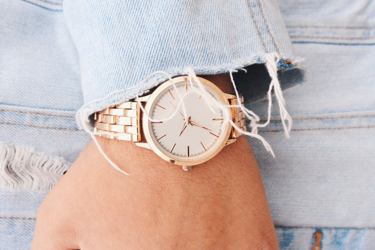 A close-up of a person’s wrist, wearing an elegant gold watch.