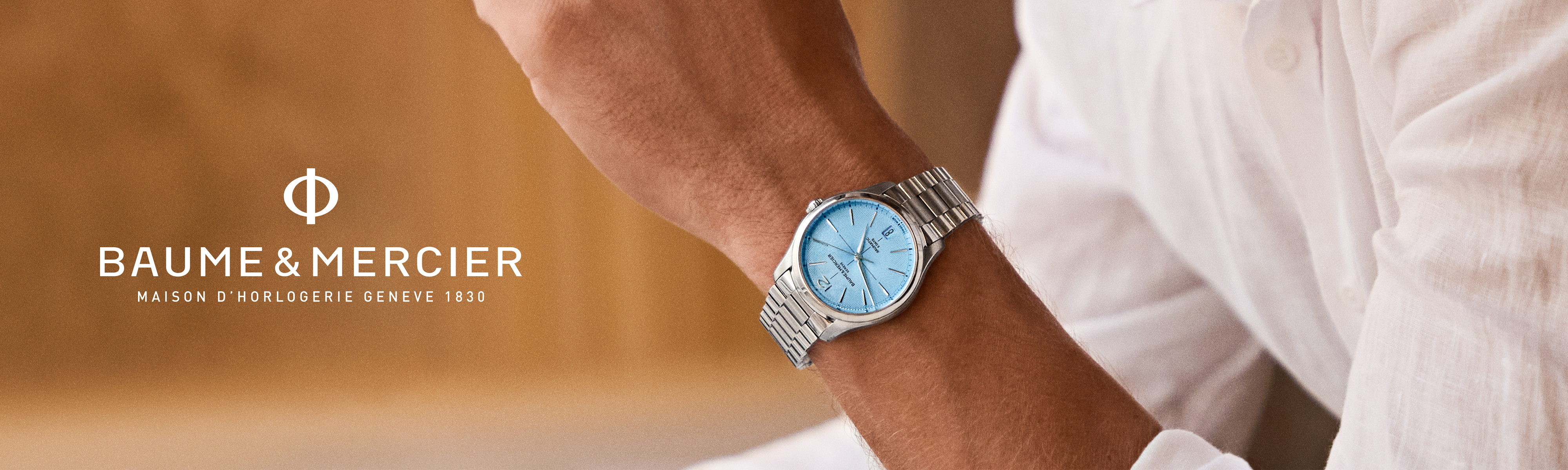 A hand with a watch on the wrist with text Baume and Mercier.