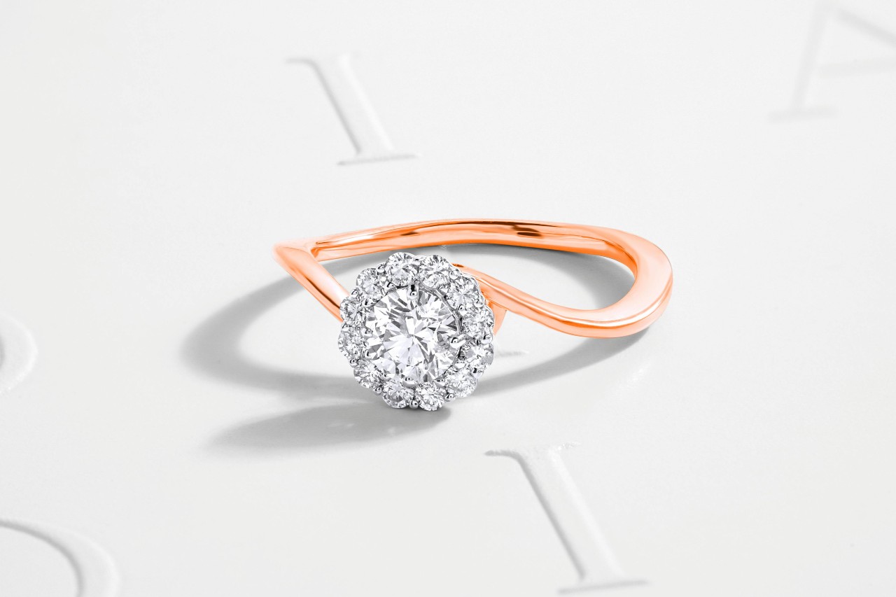 A mixed metal engagement ring featuring a rose gold band.