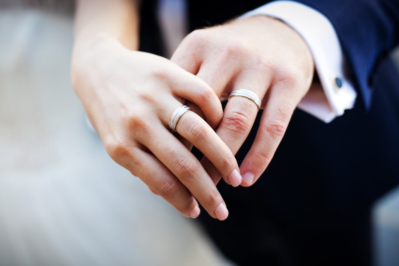 a bride and groom with matching wedding bands