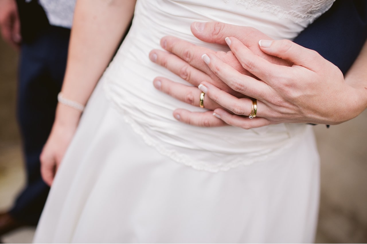 a couple with yellow gold wedding bands 